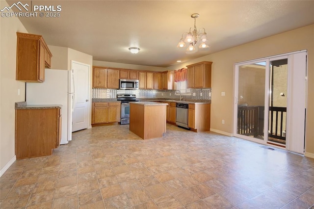 kitchen featuring stainless steel appliances, visible vents, decorative backsplash, a sink, and a kitchen island