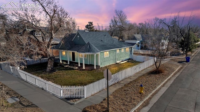 farmhouse with a fenced front yard and roof with shingles