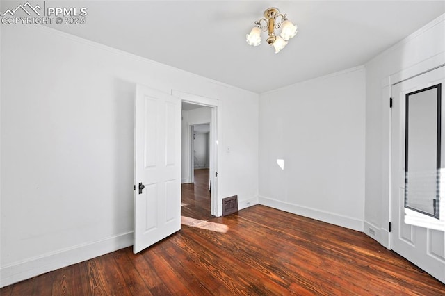 unfurnished bedroom featuring dark wood-type flooring, visible vents, crown molding, and baseboards