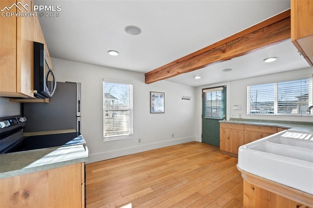 kitchen featuring stainless steel appliances, light wood-type flooring, beam ceiling, and baseboards