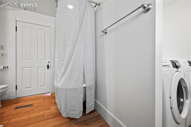 laundry area featuring laundry area, separate washer and dryer, light wood-style flooring, and baseboards