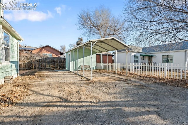 view of outbuilding with a fenced front yard and a detached carport