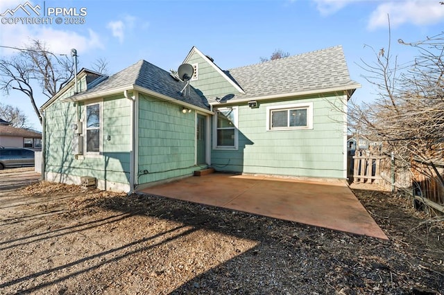 back of house with a patio area, fence, driveway, and roof with shingles