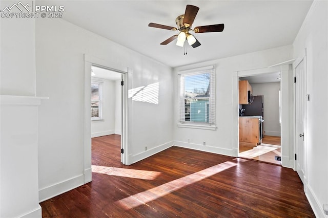 unfurnished room featuring baseboards, ceiling fan, and hardwood / wood-style floors