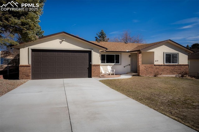 single story home featuring a garage, brick siding, driveway, stucco siding, and a front yard