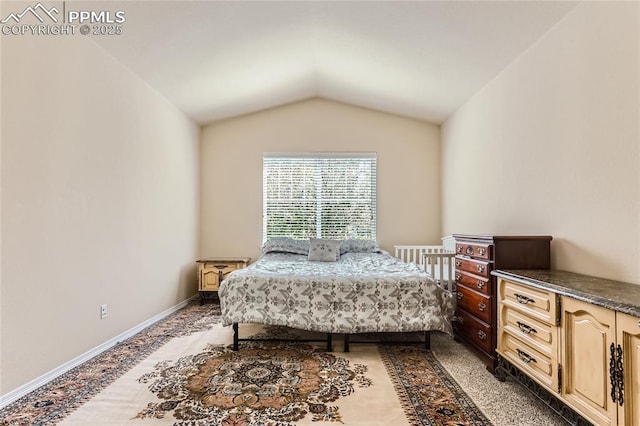 bedroom featuring vaulted ceiling, light carpet, and baseboards