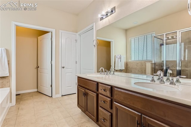 bathroom featuring a stall shower, tile patterned flooring, a sink, and double vanity