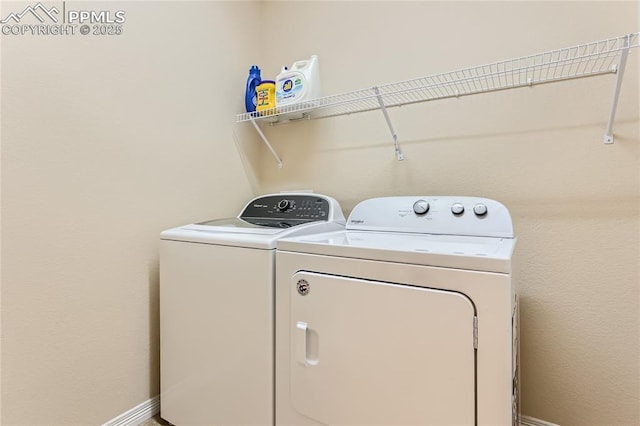 laundry room with laundry area, baseboards, and separate washer and dryer