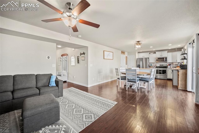 living room with dark wood-style floors, recessed lighting, visible vents, a ceiling fan, and baseboards