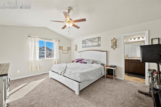 bedroom featuring baseboards, light colored carpet, lofted ceiling, ceiling fan, and ensuite bathroom