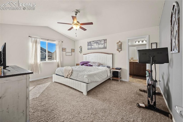 bedroom with connected bathroom, light carpet, vaulted ceiling, and baseboards