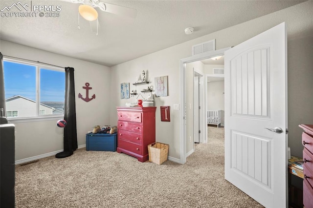 carpeted bedroom with baseboards, visible vents, ceiling fan, and a textured ceiling