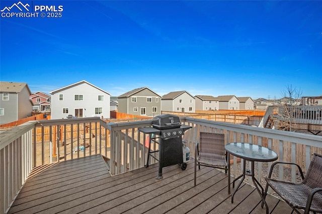 wooden deck with grilling area, fence, and a residential view