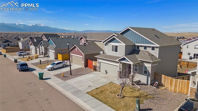 view of front of home with a residential view, a mountain view, fence, and board and batten siding