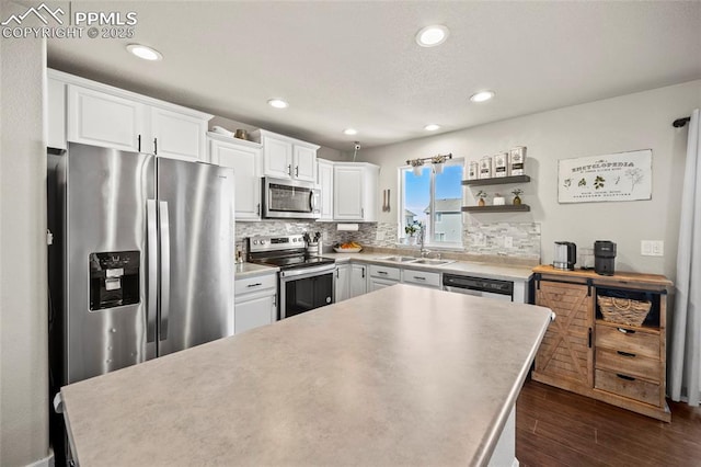 kitchen with tasteful backsplash, appliances with stainless steel finishes, dark wood-style flooring, white cabinetry, and a sink