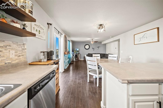 kitchen featuring dark wood-style floors, white cabinetry, light countertops, decorative backsplash, and dishwasher