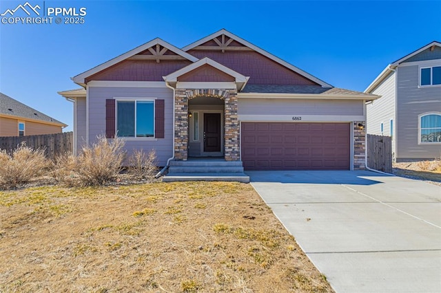 craftsman-style house featuring driveway, stone siding, an attached garage, and fence