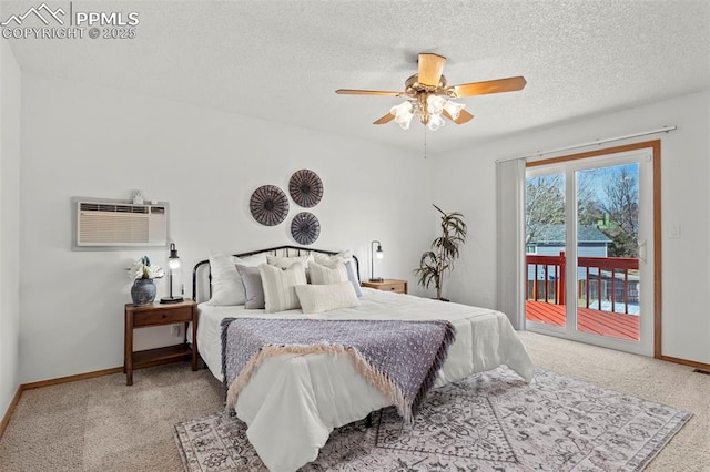 carpeted bedroom with access to outside, baseboards, a textured ceiling, and a wall mounted air conditioner