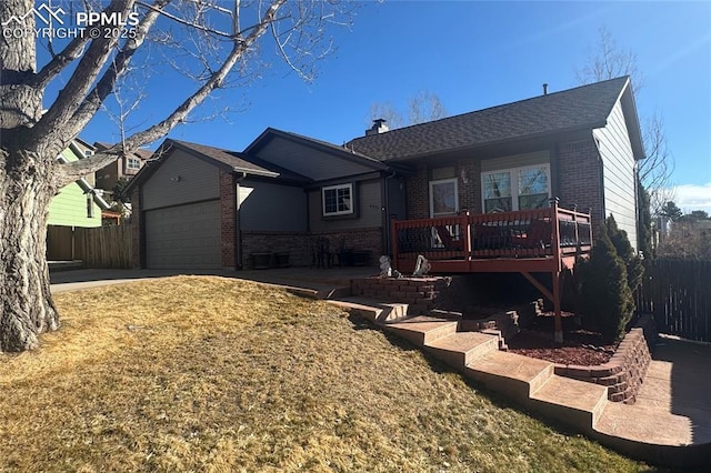 view of front of home with a garage, brick siding, fence, and a wooden deck