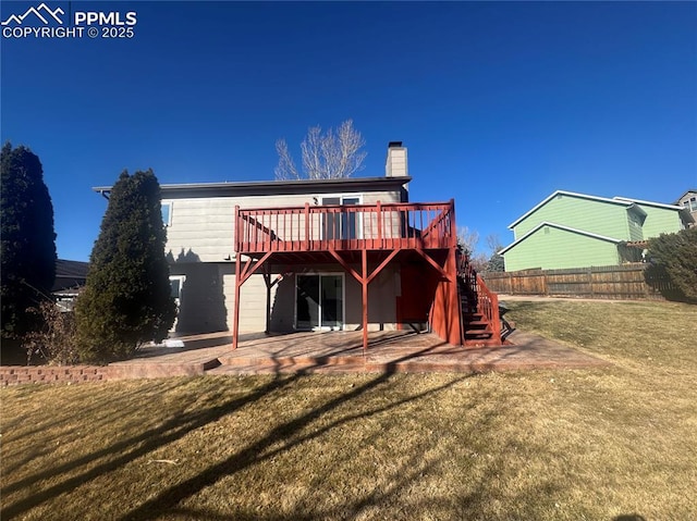 rear view of property featuring a yard, a patio area, fence, a wooden deck, and stairs