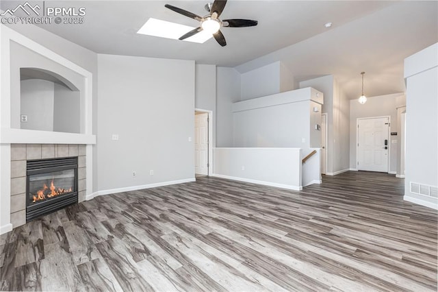 unfurnished living room with a fireplace, wood finished floors, visible vents, and baseboards