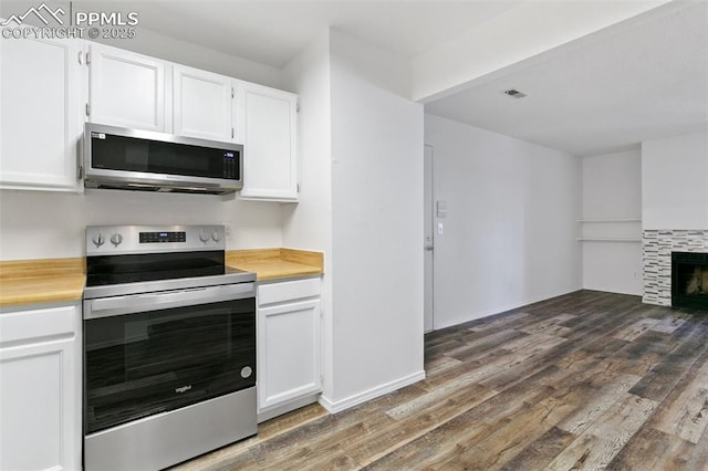 kitchen featuring white cabinets, visible vents, stainless steel appliances, and wood finished floors