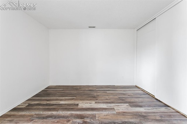 spare room featuring wood finished floors and visible vents