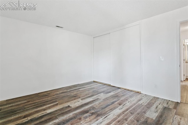 spare room with visible vents and wood finished floors