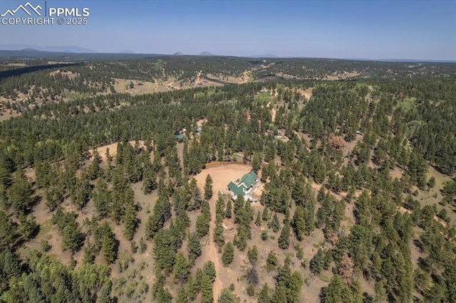 bird's eye view with a wooded view