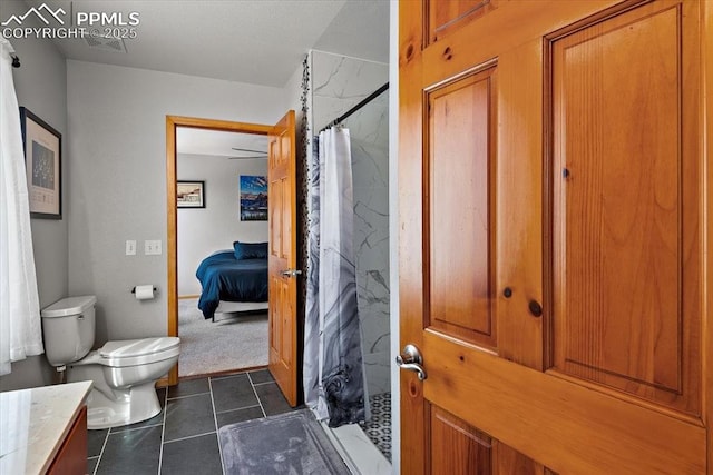 bathroom featuring toilet, a shower with curtain, vanity, and tile patterned floors