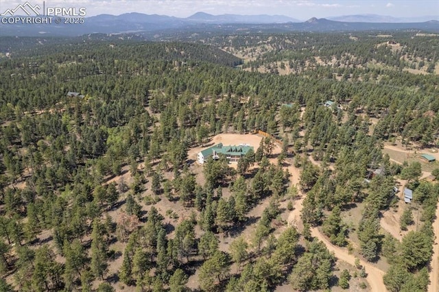 drone / aerial view featuring a mountain view and a wooded view