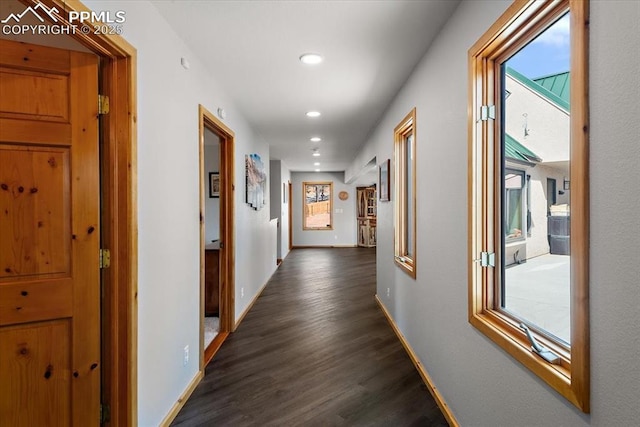 corridor featuring dark wood-style flooring, recessed lighting, and baseboards