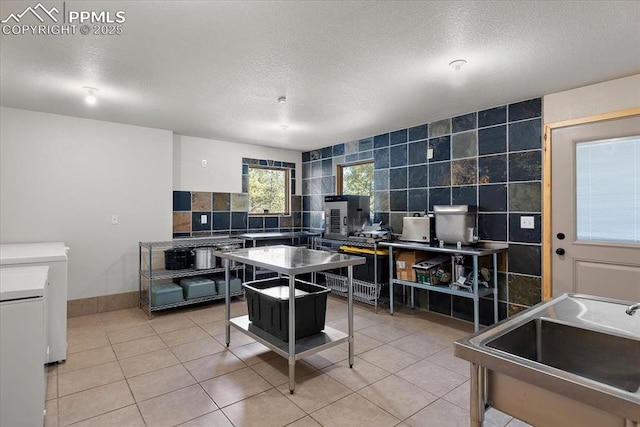 kitchen with tile walls, washer / clothes dryer, backsplash, light tile patterned flooring, and a textured ceiling