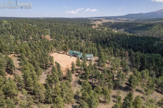 drone / aerial view with a forest view and a mountain view