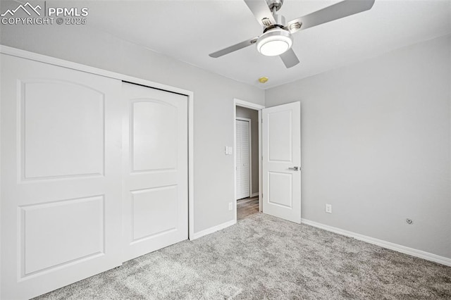 unfurnished bedroom with carpet floors, a closet, a ceiling fan, and baseboards