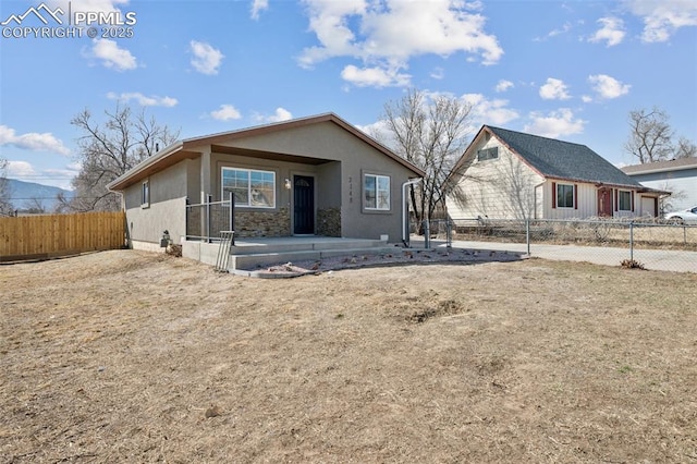 view of front of property featuring fence, a patio, and stucco siding