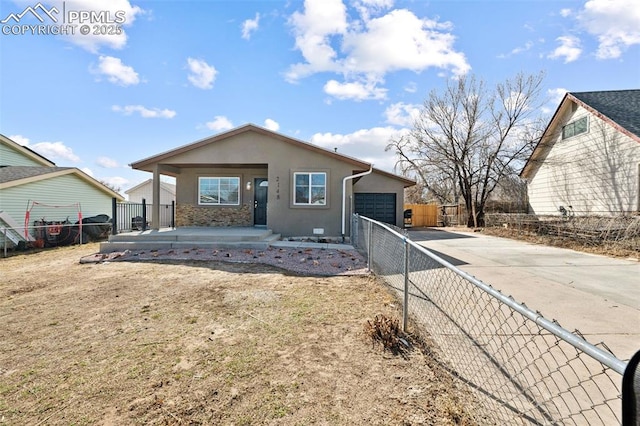 view of front of home with stucco siding, a porch, an attached garage, fence, and driveway