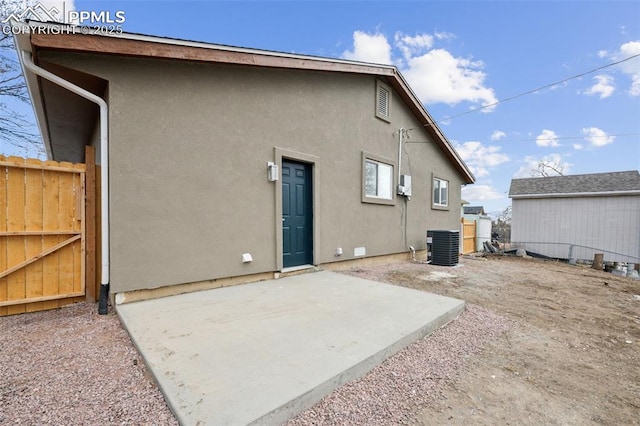 rear view of property with a patio area, fence, and stucco siding