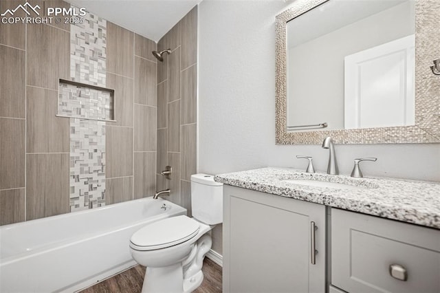 full bath with  shower combination, vanity, wood finished floors, and toilet