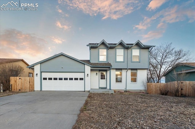 traditional-style house with concrete driveway, fence, and an attached garage