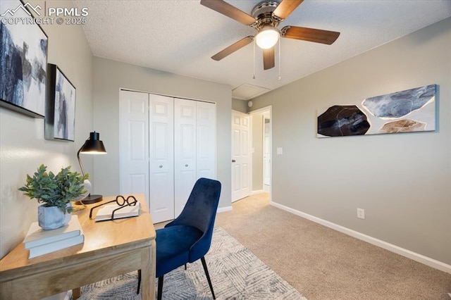 carpeted office with ceiling fan, baseboards, and a textured ceiling