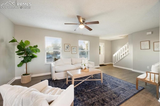 living room with a textured ceiling, stairway, wood finished floors, and baseboards