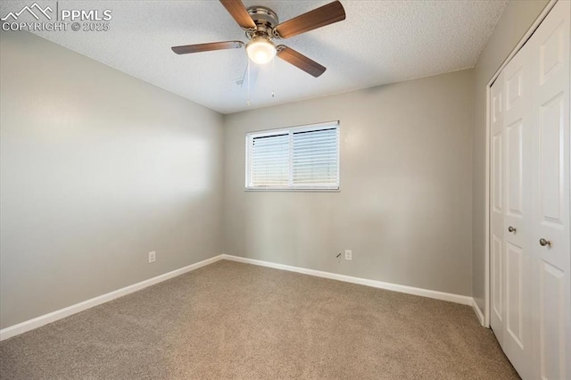 unfurnished bedroom with baseboards, ceiling fan, a textured ceiling, carpet floors, and a closet