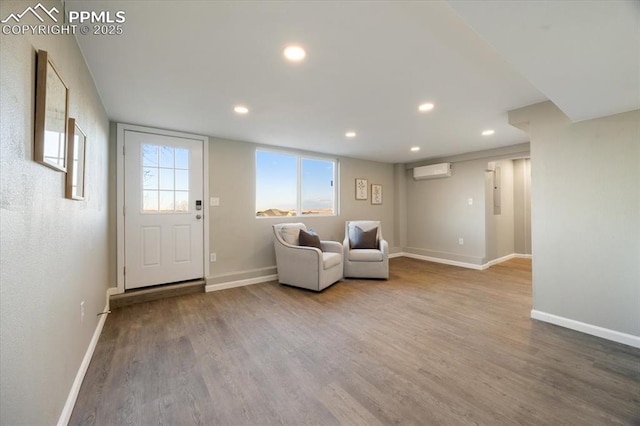 unfurnished room featuring recessed lighting, wood finished floors, baseboards, and a wall mounted AC