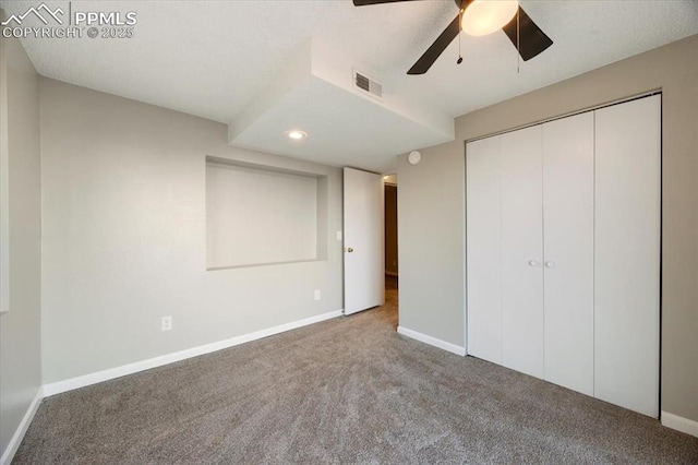 unfurnished bedroom with carpet, a closet, visible vents, a ceiling fan, and baseboards