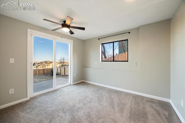 empty room with carpet, a textured ceiling, baseboards, and a ceiling fan