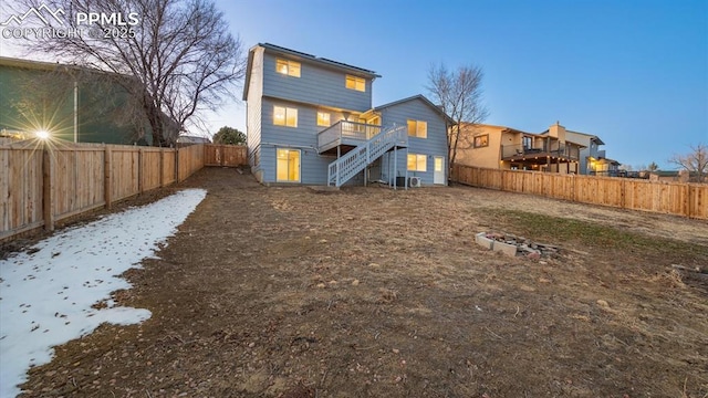 back of house with stairs, a deck, and a fenced backyard