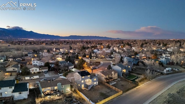 aerial view at dusk featuring a residential view and a mountain view