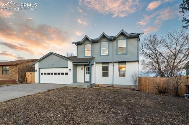 traditional home with concrete driveway, an attached garage, and fence