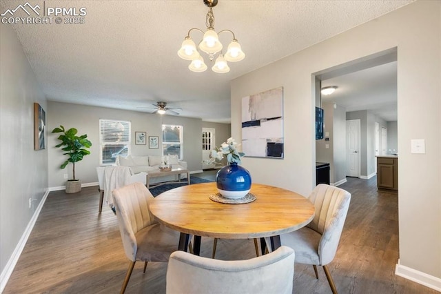 dining area with baseboards, dark wood finished floors, a textured ceiling, and ceiling fan with notable chandelier